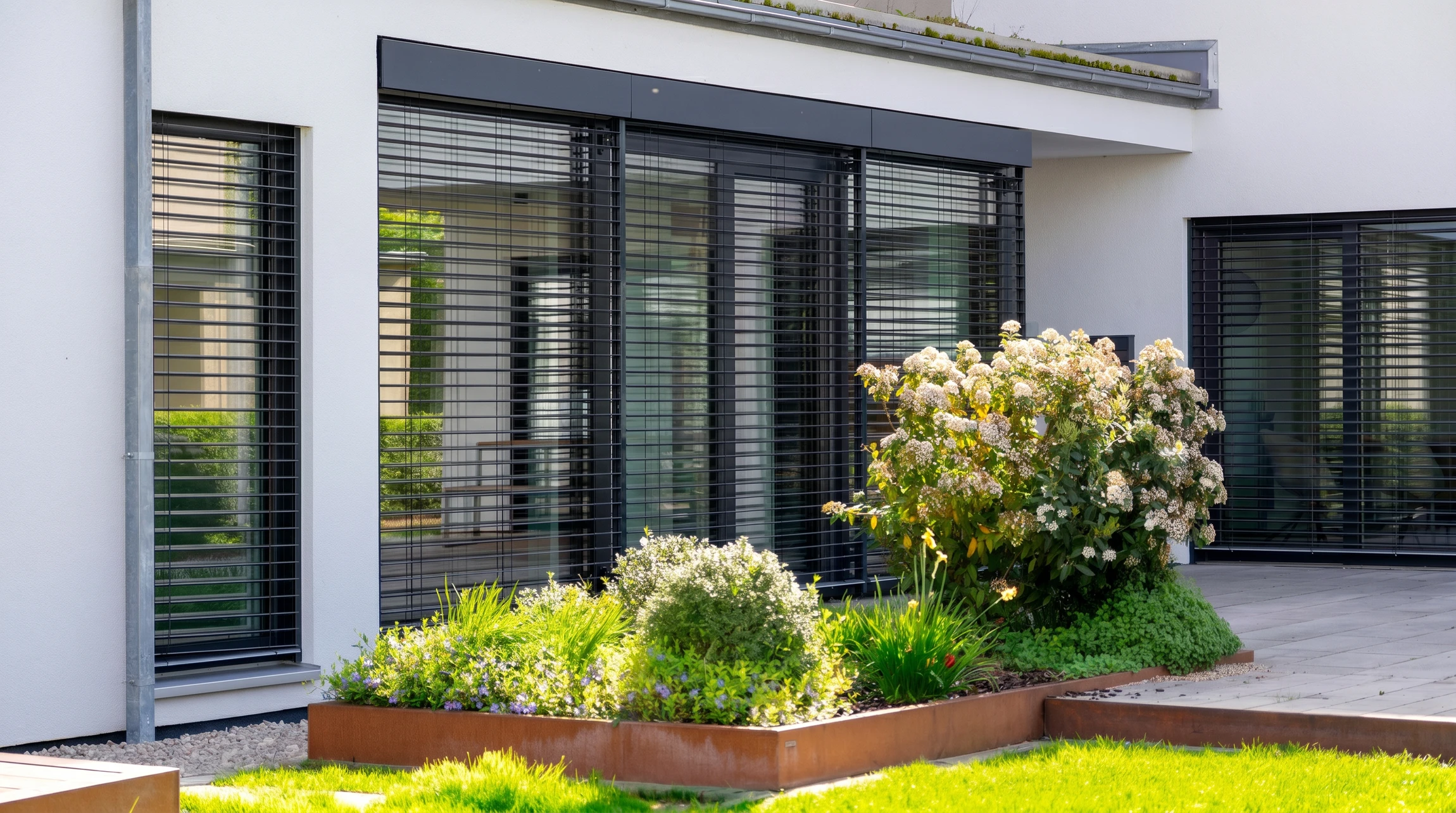 Façade de maison moderne avec volets roulants électriques gris anthracite en position fermée