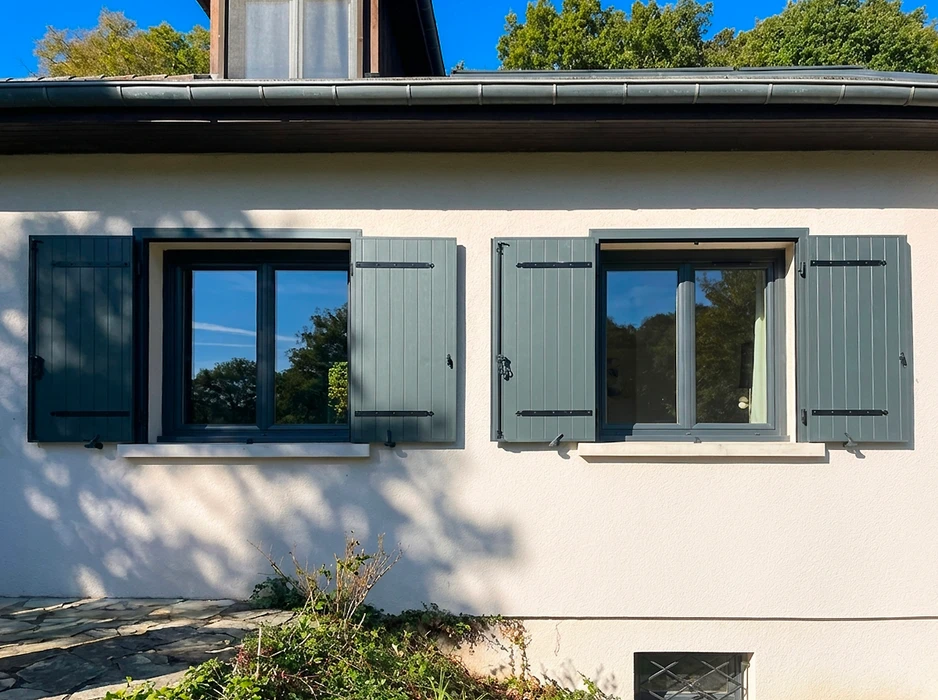 Pergola bioclimatique autoportante en aluminium anthracite, installée sur une terrasse en composite imitation bois