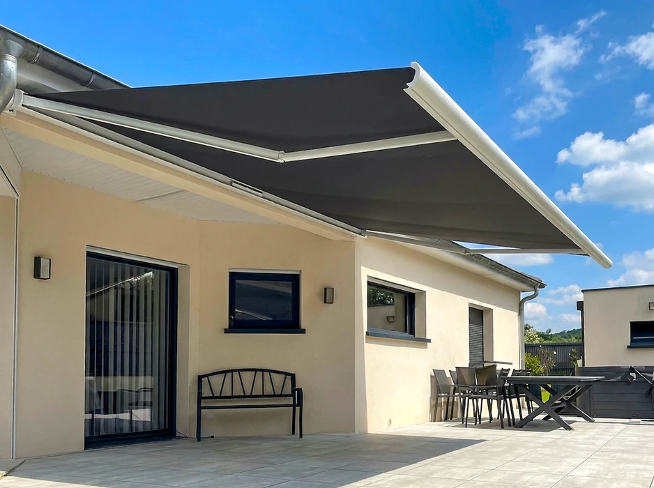 Pergola bioclimatique autoportante en aluminium anthracite, installée sur une terrasse en composite imitation bois