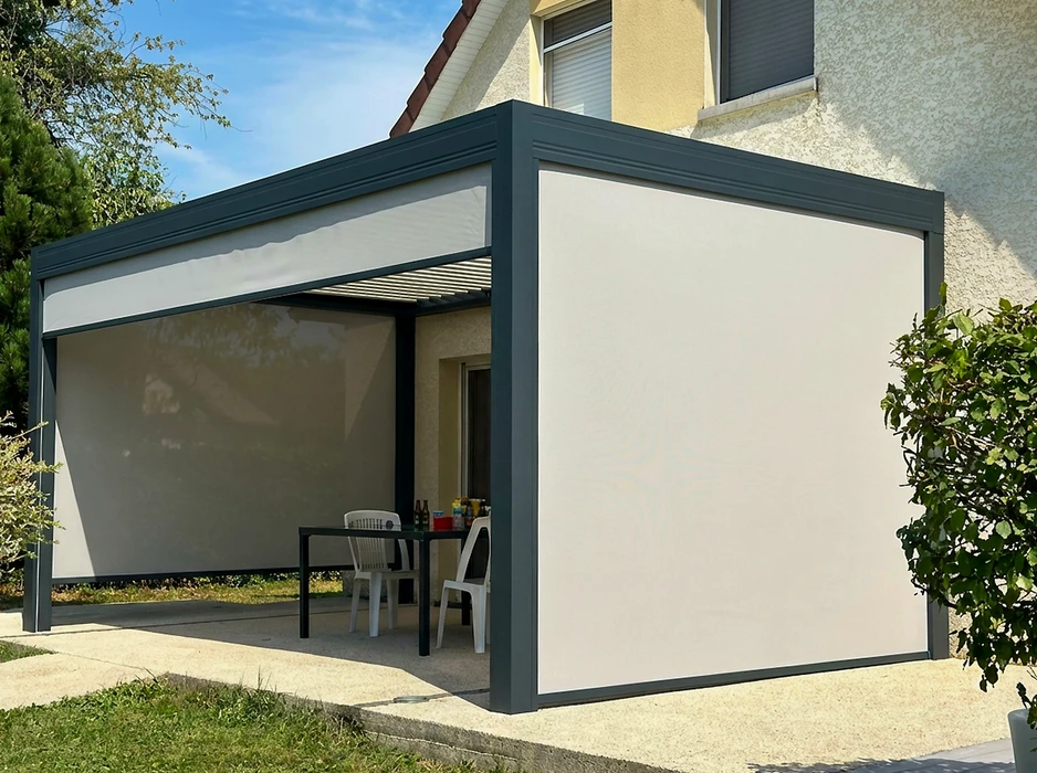Pergola bioclimatique autoportante en aluminium anthracite, installée sur une terrasse en composite imitation bois