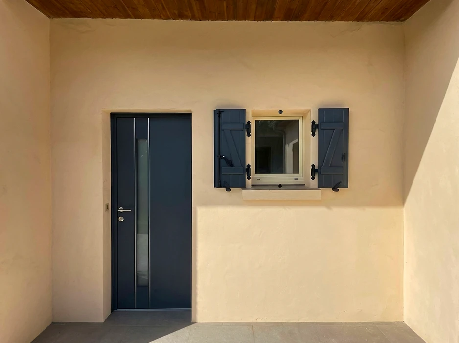 Terrasse extérieure avec pergola bioclimatique à lames orientables en aluminium anthracite, fixée en applique murale