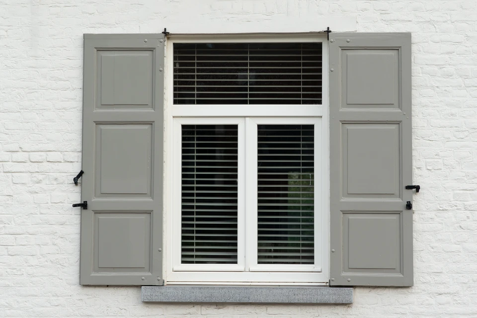 Deux artisans effectuent des mesures de fenêtre dans un intérieur résidentiel moderne