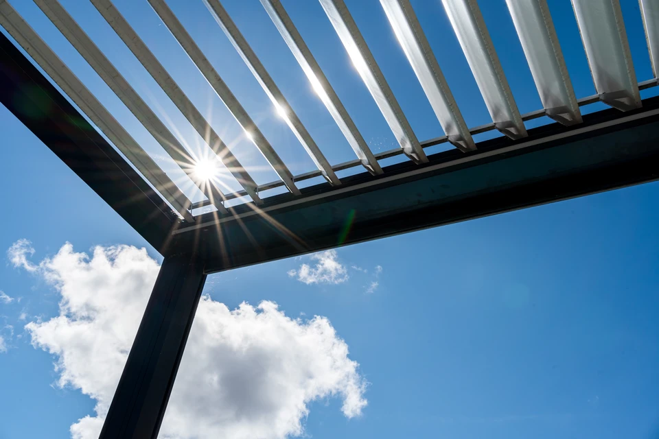 Maison résidentielle avec pergola en bois naturel adjacent à une terrasse surélevée