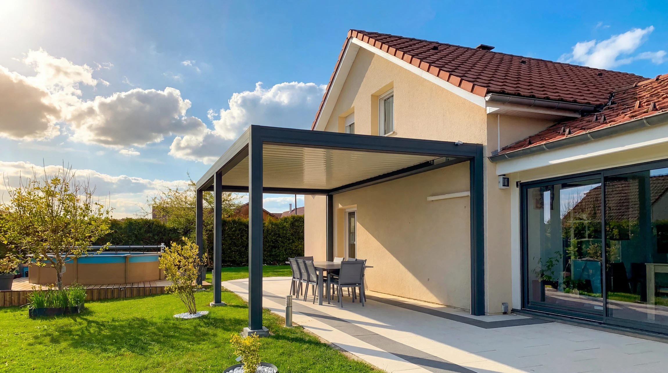 Terrasse extérieure résidentielle moderne avec pergola métallique à structure aluminium gris anthracite et couverture polycarbonate translucide