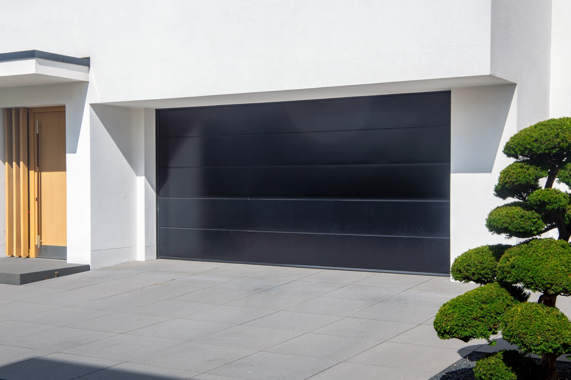 Garage résidentiel moderne avec deux portes sectionnelles métalliques blanches fermées